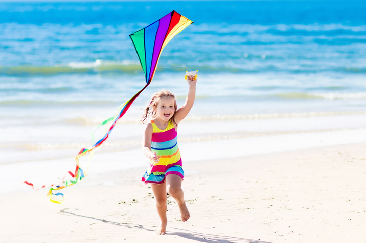 Child flying kite on tropical beach s
